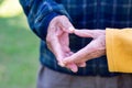 Close-up of the elderly couple showing making a heart with fingers. Concept of aged people and love Royalty Free Stock Photo