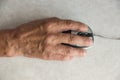 Close-up of an elderly man`s hand on a computer mouse. older people are learning new computer technologies.