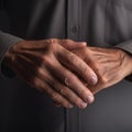 Close-up of an elderly man\'s hands against the background of a dark gray shirt