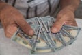 Close-up of an elderly man`s hands holding American dollar bills, calculating a home budget. Devaluation concept, selective focus Royalty Free Stock Photo