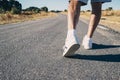 Close-up of an elderly man`s legs walking down the road