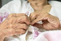 Elderly woman fasten buttons on dress , progressive brain disorder ,Close up hand