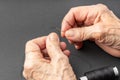 Close up of elderly woman hands pulling thread into the needle Royalty Free Stock Photo