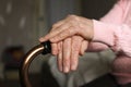 Close up of elderly woman holding a walking cane in nursing home.