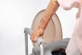 Elderly woman using mobile toilet seat chair