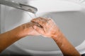 Close-up of an elderly woman washes her hands with soap and foam in sink, disinfects, protection from bacteria and viruses. Royalty Free Stock Photo