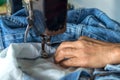 Repair jeans with an old sewing machine. Royalty Free Stock Photo
