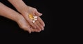 Black background, In the hands of an elderly woman different types of medicines