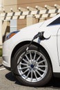 Close-up of electric car vehicle auto with cable plugged into connected to electric charging station
