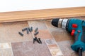 Furniture assembly parts and tools for self assembly furniture, on the floor.Installation of plastic floor plinth. Interior detail