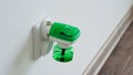 Close-up an electric green fumigator in socket protect against insect bites on white wall background,selective soft focus. Royalty Free Stock Photo