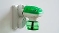 Close-up an electric green fumigator in socket protect against insect bites on white wall background,selective soft focus. Royalty Free Stock Photo