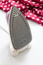 Close-up of electric iron on fabric background. Royalty Free Stock Photo