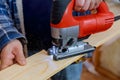 Close up electric jigsaw cutting a piece of wood