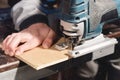 Close-up electric jigsaw in the hands of a worker in a home workshop. Starting a business. Craftsman Royalty Free Stock Photo