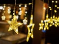 Close up of electric lighted stars with warm yellow lights against a dark backdrop. Festive / holiday mood concept