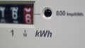 A close-up of an electric meter and kWh symbol.