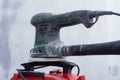 Close-up of electric sander connected to a dust extractor vacuum during wall sanding work. Concept construction tools covered in Royalty Free Stock Photo