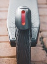 Close-up of electric scooter wheel and light reflector.