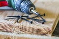 Close up of electric screwdriver with some screws laying on old Royalty Free Stock Photo