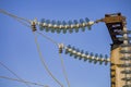 Close-up of electrical glass strain insulators on wiring in a converter station, special type of transformer substation. Blue sky Royalty Free Stock Photo