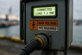 Close-up of electrical panel at harbor showing high voltage warning and energy load display for shore power connection system Royalty Free Stock Photo