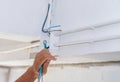 Close up electrician hand pulling wire into PVC Conduit Royalty Free Stock Photo