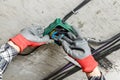 Close up of electrician' hands in working gloves mounting electrical junction box with wires Royalty Free Stock Photo