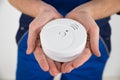 Close-up Of Electrician Holding Smoke Detector