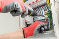 Close up of electrician's hands in working gloves installing and maintainin electrical junction box