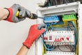 Close up of electrician's hands in working gloves installing and maintainin electrical junction box