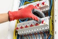 Close up of electrician\'s hands in working gloves installing and maintainin electrical junction box