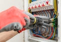 Close up of electrician's hands in working gloves installing and maintainin electrical junction box