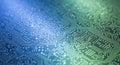 Close up of electronic circuit board with blue and green glowing lights showing complex microchip pathways and high tech hardware Royalty Free Stock Photo