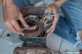 Close up of an electronic worker hand opening a broken coil while repairing a water pump machine