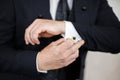 Close-up of elegance male hands wearing modern black suit