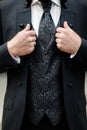 Close-up of elegance male hands wearing modern black suit