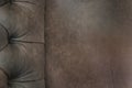 Close-up of elegant Chesterfield chair. Brown leather chair. Seat and back with buttons. With free space for text. Royalty Free Stock Photo