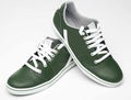 Close up of elegant dark green sports shoes in natural  leather for adult men photographed on a white background. Fashion Royalty Free Stock Photo