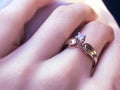 Close up of elegant diamond ring on the finger with gray Scarf background. Diamond ring.