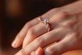 Close up of an elegant engagement diamond ring on woman finger. love and wedding concept. Diamond ring on young lady