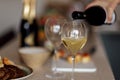 Close-up of an elegant glass with a long stem with champagne. The process of pouring sparkling wine into a goblet