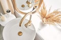 Close-up of an elegant golden faucet in the bathroom sink next to stylish decorations. A beautiful sink with a golden Royalty Free Stock Photo