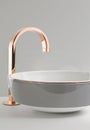 Close-up of an elegant rose golden faucet in the bathroom sink next to stylish decorations. A beautiful sink with a Royalty Free Stock Photo