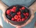 Female hands holding a bowl full of blackberries and raspberries Royalty Free Stock Photo