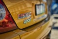 close up of an emblem on a yellow car that is parked