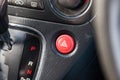 Close-up of an emergency button with a white triangle icon on the red plastic of a car dashboard. Signal of breakage, problem, or Royalty Free Stock Photo