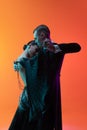 Close-up emotive dancing couple, beautiful man and woman dancing waltz over gradient orange pink background in