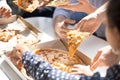 Close up of employees eating pizza spend work break together Royalty Free Stock Photo