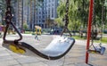 Close up empty baby swing in the park. New chain swing. Set of black swing chains on a modern playground. Focus on the swing in